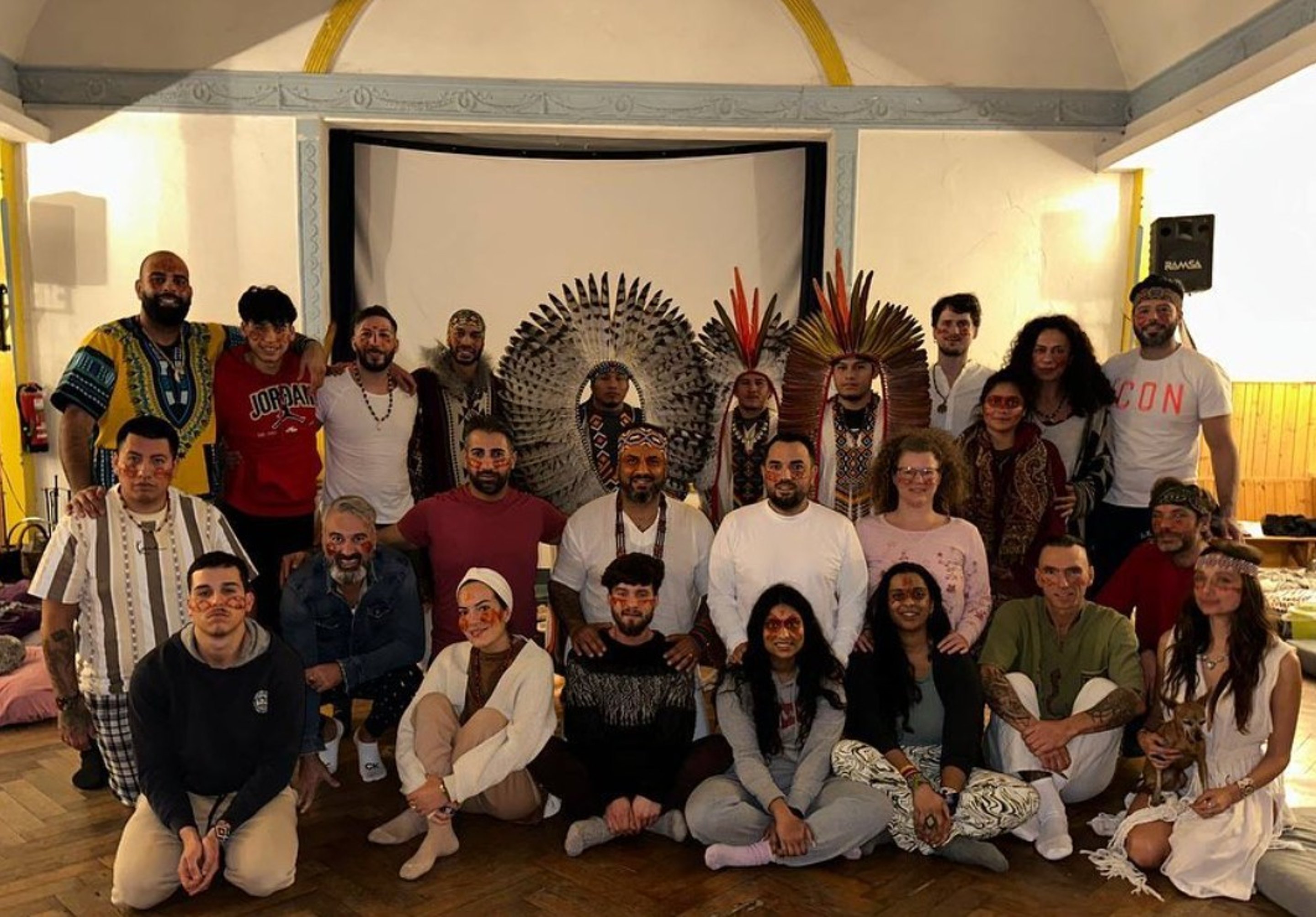 Teilnehmer:innen eines MD-Retreat-Zeremoniekreises mit Federschmuck